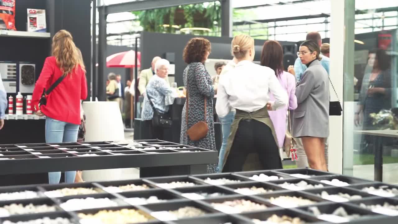 Bezoekers bekijken materiaalstalen in de showroom van LujoGardens