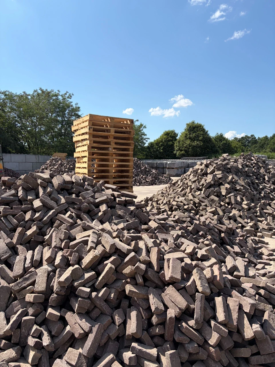 Partijen gebruikte klinkers en gestapelde pallets op het terrein van LujoGardens