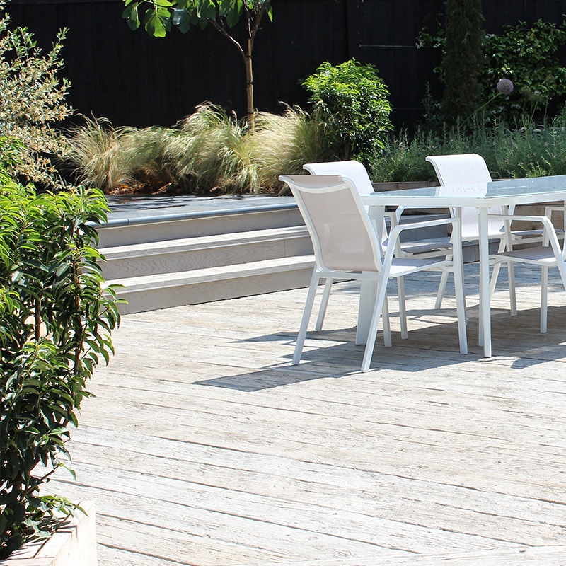 Terras met witte eettafel en tuinstoelen