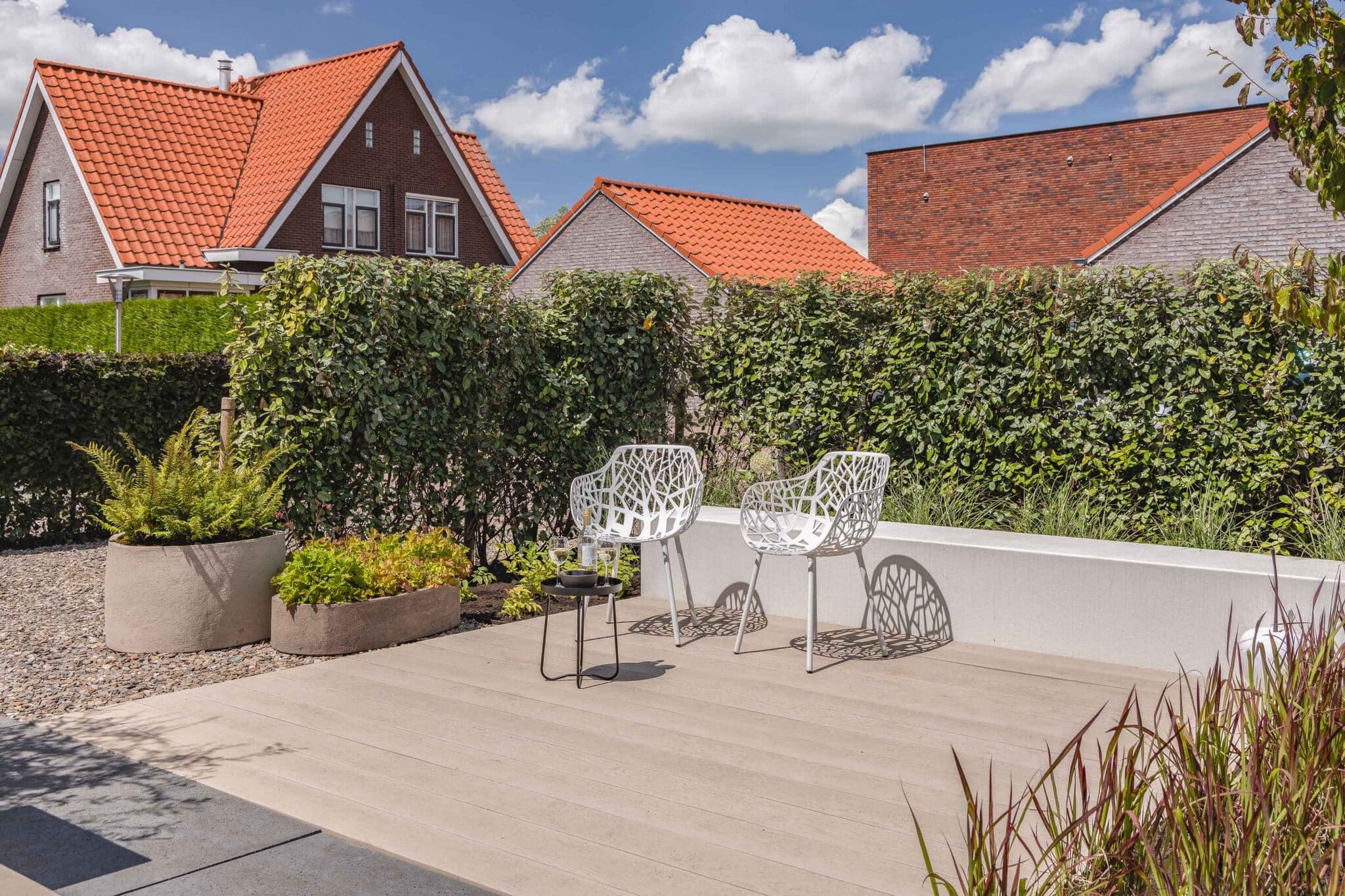 Voortuin met vlonderterras en groene beplanting