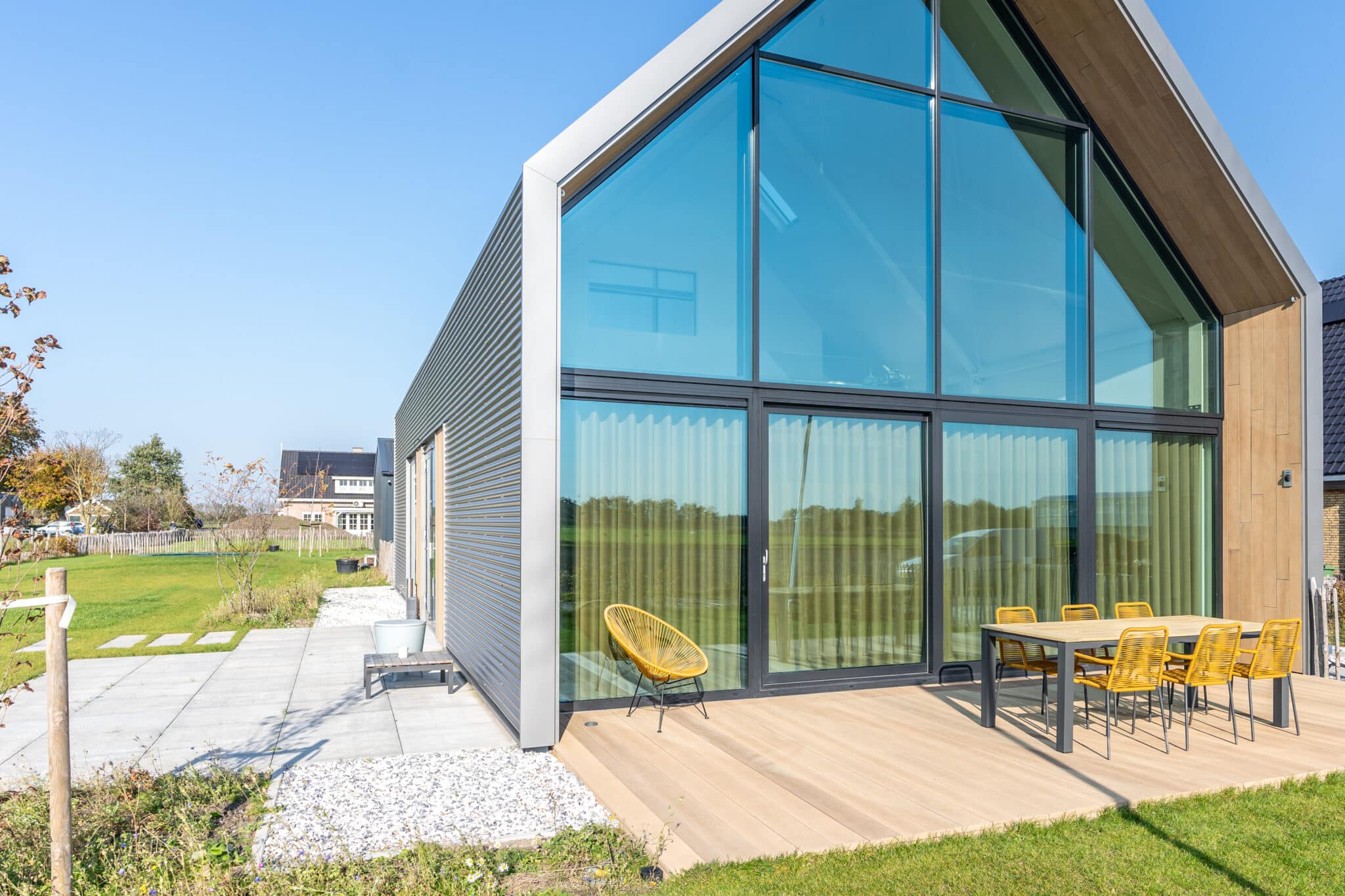 Lofthome met houten uitstraling rond de glazen gevel en op het terras