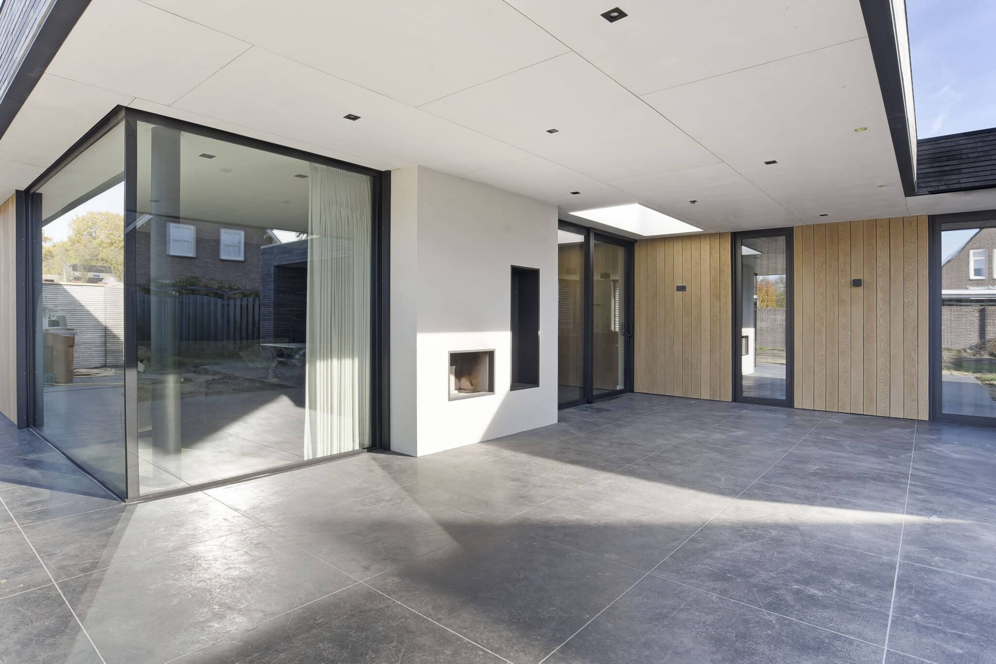 Overdekte buitenruimte met glas en verticale gevelbekleding