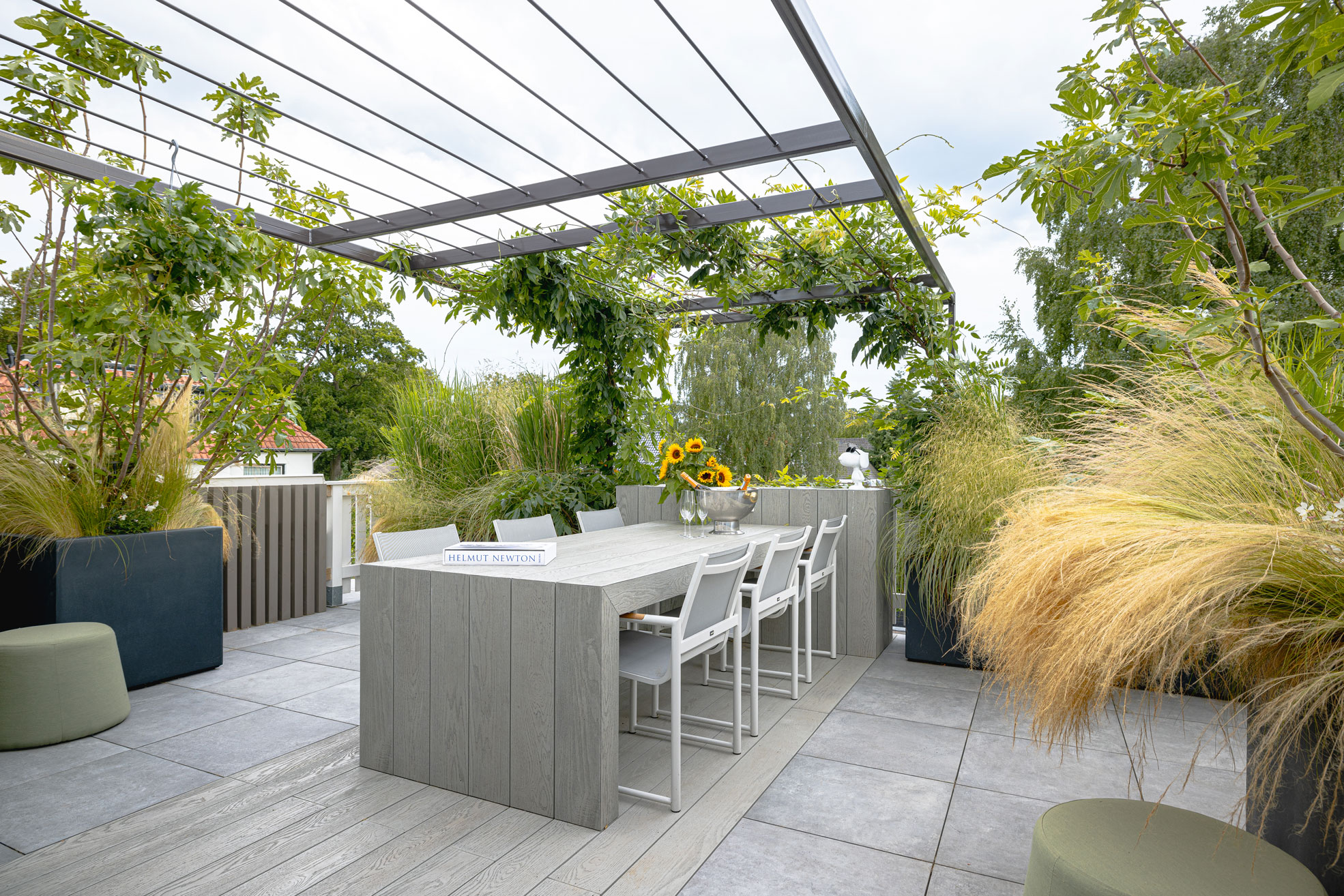Zithoek en eetgedeelte tussen siergrassen op het dakterras