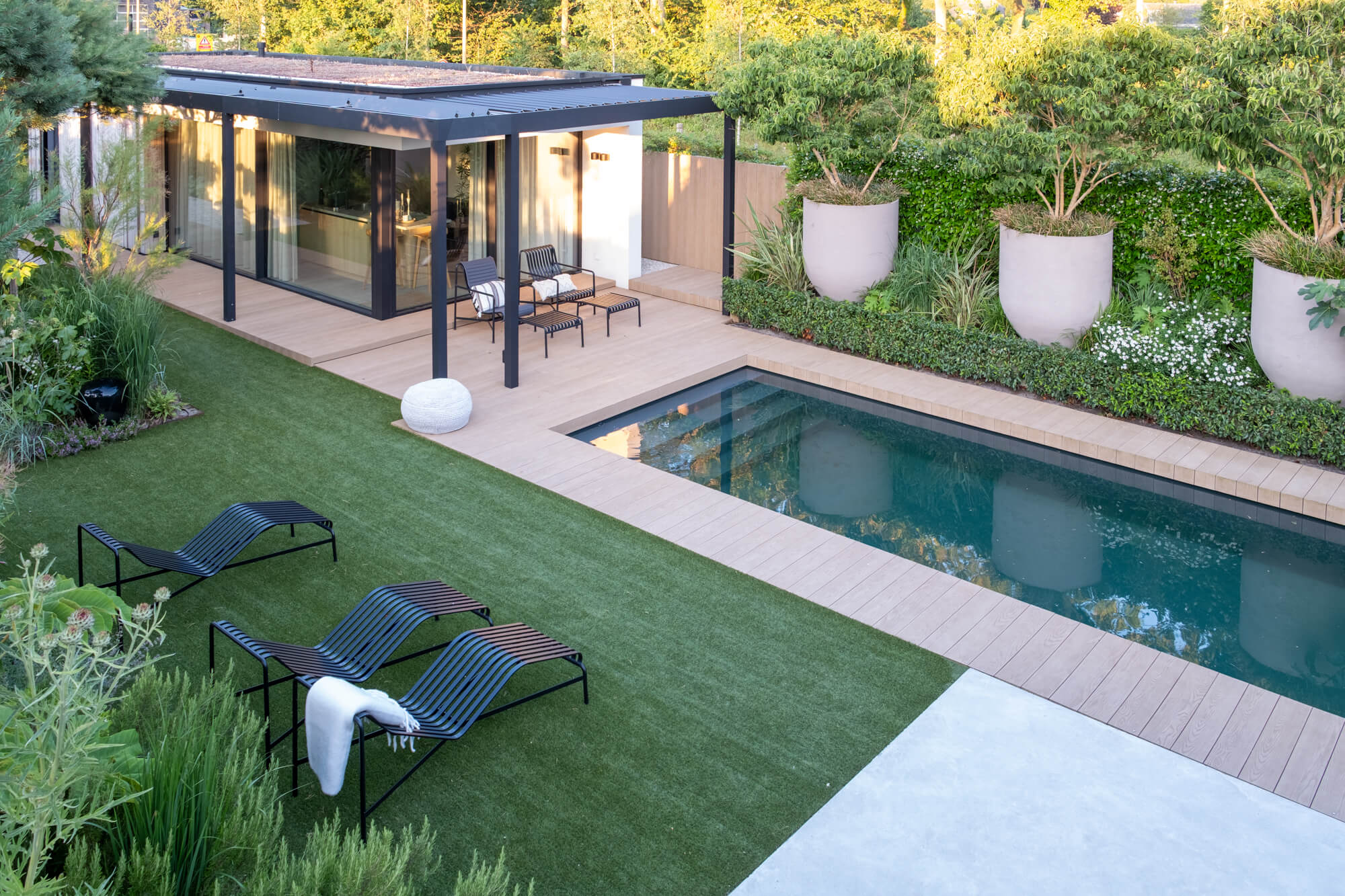 Overzicht van zwembad, ligplekken en poolhouse