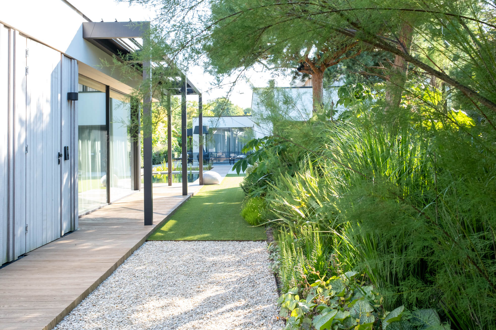 Vlonderpad langs de woning en de beplanting in Renesse