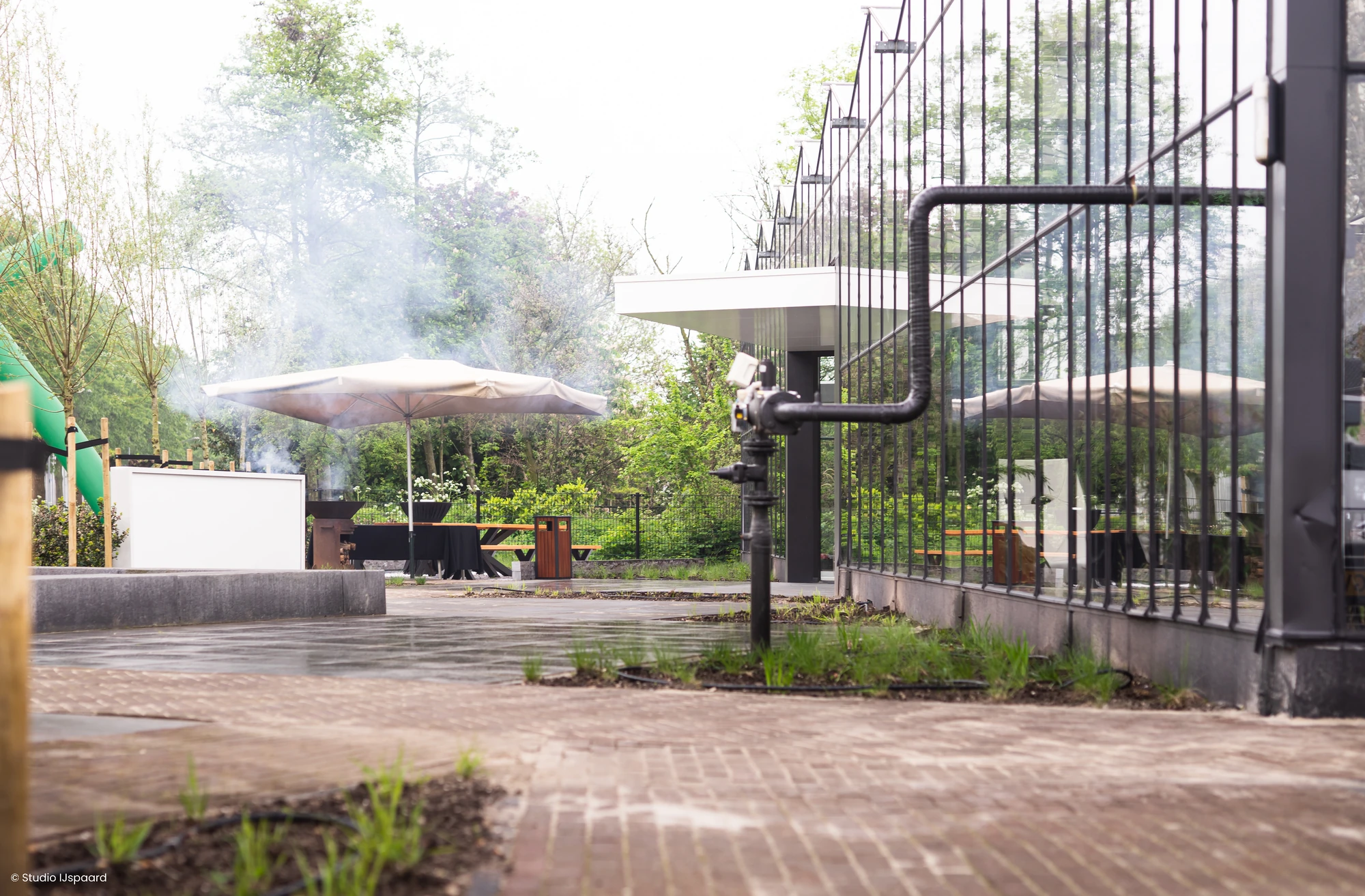 Glazen gevel en bestrate route bij het inspiratiecenter van LujoGardens