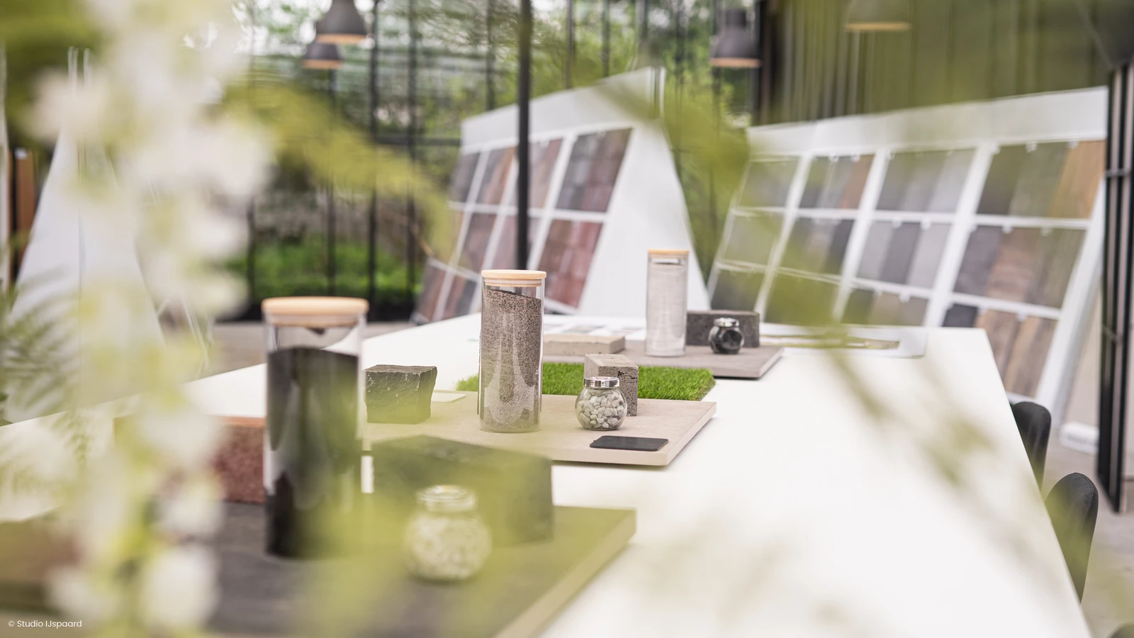 Materiaalstalen en tegelpresentaties op de inspiratietafel in onze showroom.