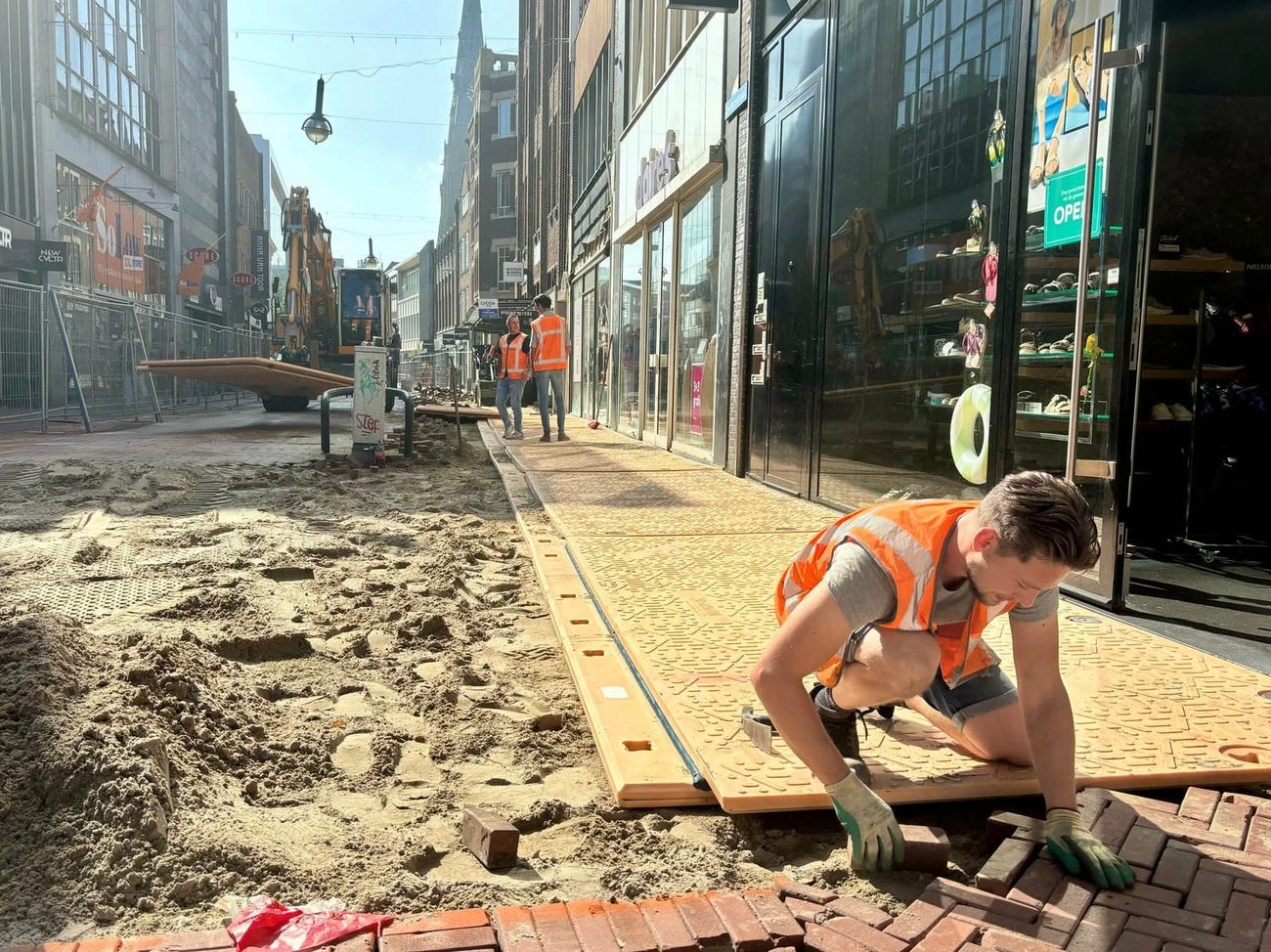 Stratenmaker aan het werk in de Eindhovense winkelstraat
